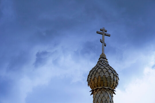 Wooden chapel's dome with orthodox cross on the top with cloudy sky background. Religious symbol. Faith concept. - Powered by Adobe