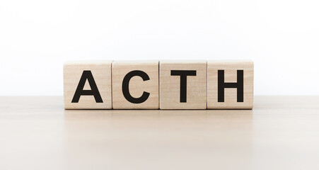 ACTH word written on wooden cubes on on an isolated light background. insurance and medical concept