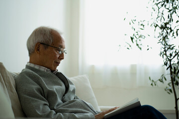 Naklejka premium 読書をする日本人シニア男性