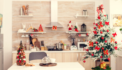 Kitchen on christmas day with nobody in the room decorated with x-mas tree and garlands.