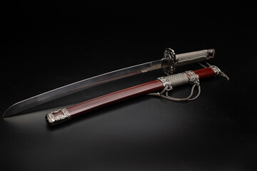 Naklejka premium Beautiful katana sword with sheath and stand on a black background