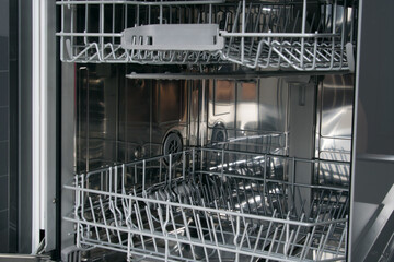 close-up of the inside of the dishwasher with empty nets for plates, forks, spoons and glasses