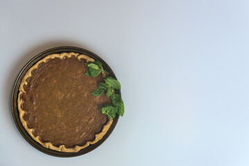 Thanksgiving background. Delicious pumpkin pie with fresh mint leaves on light gray background with copy space. Man cooking. Dublin, Ireland