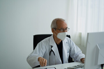Fototapeta na wymiar マスクをつけて働く日本人シニア男性医師