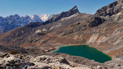 Beautiful turquoise colored mountain lake on the western ascent of Renjo La pass (5,430 m), Sagarmatha National Park, Nepal in the Himalayas, part of the challenging Three Passes Trek.