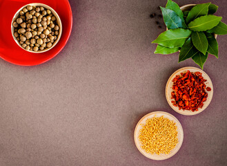flat lay of various spices in round wooden and ceramic plates, top view of paprika or chili flakes, allspice, bay leaf and mustard seeds, copy space