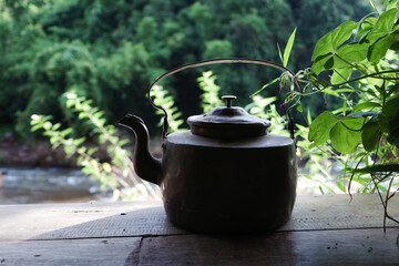 selective focus on the vintage black kettle on the wooden table with blurred background