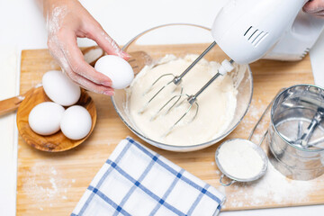 process of making dough for pancakes with ingredients on a light table, eggs and flour are whipped with a mixer