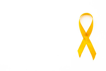 Yellow cancer awareness ribbon isolated on a white background. Top view