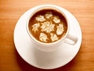 frothy coffee in a white cup on a wooden table. the concept of dating, rest, relaxation.