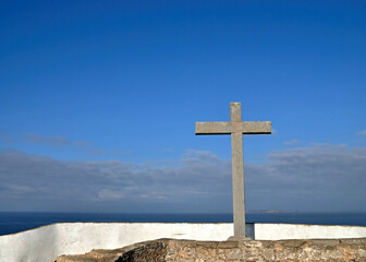 Religious  stone cross in front of blue sky