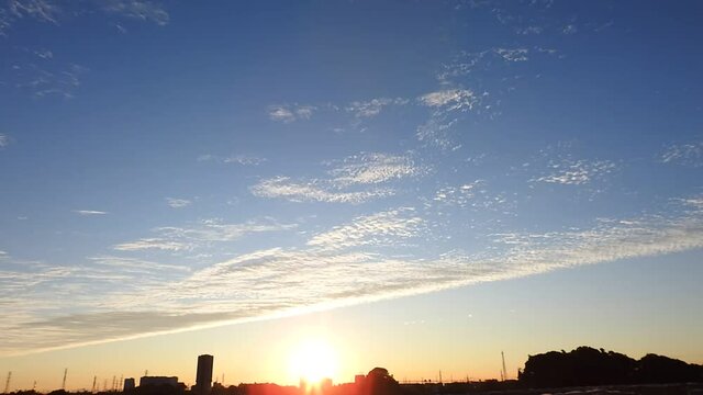 夜明けの空に現れた龍のしっぽのような鱗雲。空を二分する巻積雲。朝焼け。空の背景素材。タイムラプス動画。