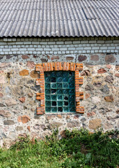 Fototapeta na wymiar Glass block window in an old stone building