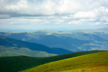 Fototapeta premium mountain landscape on a summer day. hills rolling from the valley up in to the distant ridge. view of the wonderful outdoor scenery beneath a sky with clouds