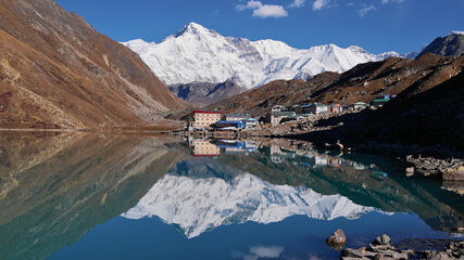 Stunning view of Sherpa village Gokyo, Sagarmatha National Park, Himalayas, Nepal and majestic snow-capped mountain Cho Oyu (8,188 m) reflected in the peaceful water of clear Gokyo lake.