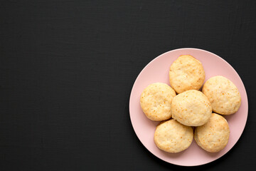 Homemade Flaky Buttermilk Biscuits on a pink plate on a black background, top view. Flat lay, overhead, from above. Copy space.