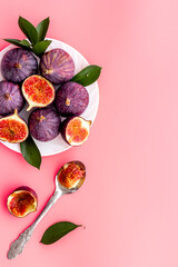 Fresh figs in on a plate with green leaves. Top view