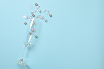 Champagne glass with snowflakes and baubles on blue background