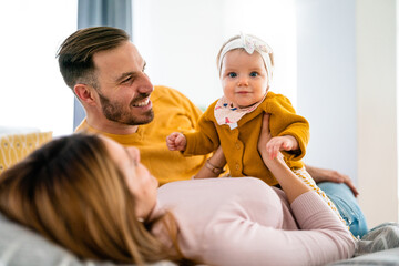 Parents enjoying playing with baby girl at home