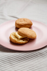 Homemade Flaky Buttermilk Biscuits on a pink plate, low angle view.