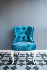 Modern design home interior with elegant blue chair in retro style over gray wall. Stylish home decor