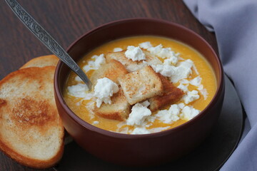 Pumpkin cream soup with a feta cheese, autumn homemade food, dark wooden background. Fodmap diet,vegetarian menu, clean eating recipe