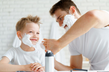 Fototapeta premium Father teaches his little son how to shave face