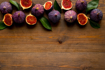 Obraz na płótnie Canvas Tasty fresh figs cut in half with leaves, top view