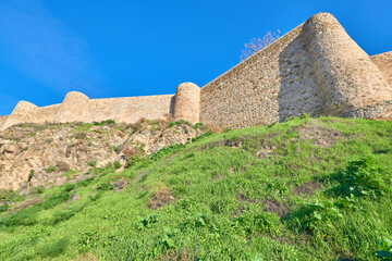 Fototapeta na wymiar Landscape low angle view of the imposing medieval stone walls from the historic center of the city of Toledo, Castilla la Mancha, Spain