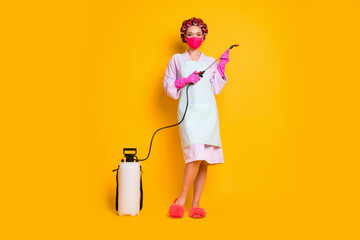Full length body size view of maid wearing safety mask using tool sanitizer isolated bright yellow color background