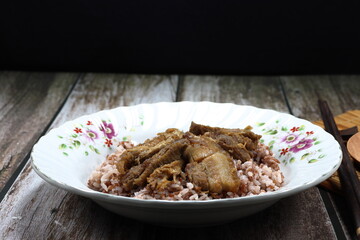 Grilled mixed pork belly and chicken meat serving with cooked rice on the plate. Famous traditional street food in Asia. Food in rush hour concept. 