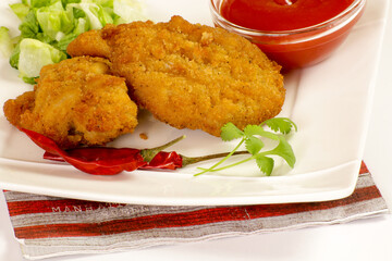 morceaux de poulet pané et sauce ketchup dans une assiette
