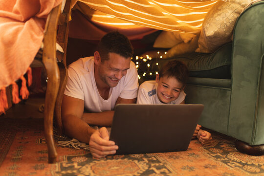 Caucasian man with his son smiling and using tablet