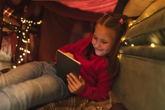 Caucasian girl smiling and using tablet computer