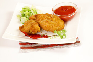 morceaux de poulet pané et sauce ketchup dans une assiette