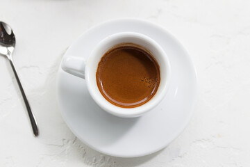 fresh strong espresso in a white cup on a white background, morning with coffee in a coffee shop