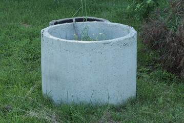 one large gray concrete circle stands outside in the green grass