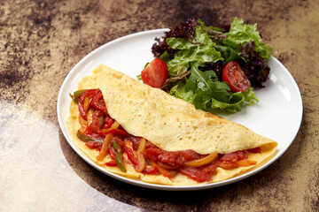 Omelette with vegetables on wooden background