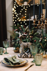 Festive table setting for Christmas dinner.  New Year holidays celebration decorations in modern interior design.