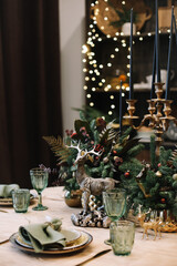 Festive table setting for Christmas dinner.  New Year holidays celebration decorations in modern interior design.