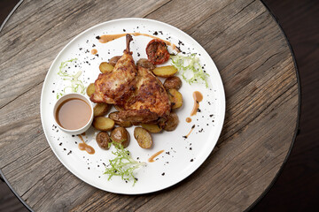 Grilled chicken Tabaka with baked potatoes and with sauce