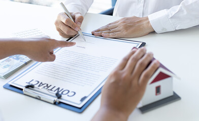 Home salesman explains the terms of buying a home to customers who need accommodation.