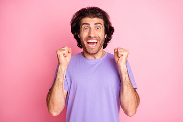 Fototapeta premium Photo of astonished guy raise fists open mouth wear purple t-shirt isolated pastel pink color background