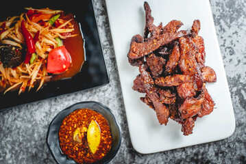 deep fried sun-dried pork (Moo dad deaw) with papaya salad(som tum), Thai food