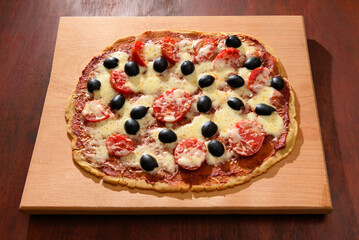 homemade pizza, vegetarian food, baked vegetables and cheese, tomatoes and olives, delicious food on a wooden background