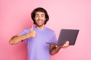 Photo of crazy funky stylish trendy brown haired man hold computer show thumb up wear purple...