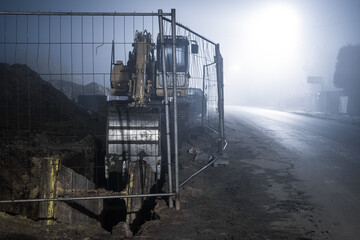 Blue excavator digger working at night on street