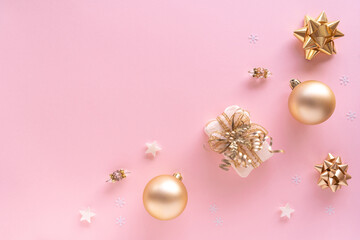 Fototapeta na wymiar Christmas composition. Gift, baubles, greeting card, golden decorations on pastel pink surface. Christmas, winter, new year concept. Flat lay, top view, copy space, from above.