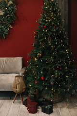 Beautiful Christmas tree with toys, baubles and gift boxes. Living room decorated for Christmas and New Year celebration