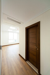 Wooden door inside the room with parquet and wallpaper and window light